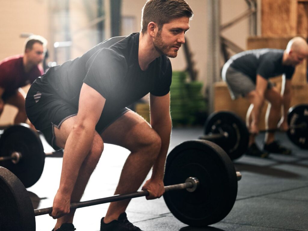 3 men deadlifting